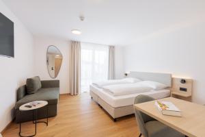 ein Hotelzimmer mit einem Bett und einem Tisch in der Unterkunft odilum - Self-Check-in-Hotel in Mondsee