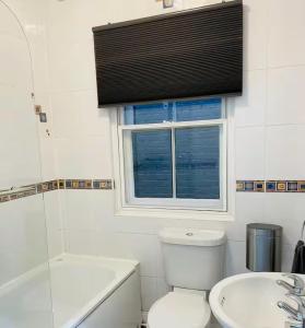 a bathroom with a toilet and a sink and a window at Entire 1 Bed Central Flat - St Albans in St. Albans +9 photos