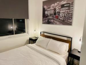 a bedroom with a white bed and two windows at Entire 1 Bed Central Flat - St Albans in St. Albans
