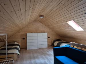 a room with two beds in a wooden ceiling at Le Rond Point in Sieraków