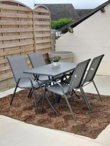 a table and four chairs on a patio at Gîte aux 3 Cep in Magnien