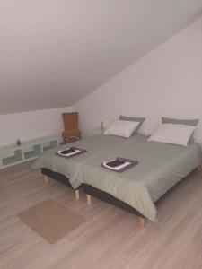 a bedroom with a large bed and a wooden floor at Gîte aux 3 Cep in Magnien