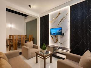 a living room with a couch and a tv on a wall at Hotel Dreamliners in Katunayaka
