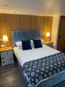 a bedroom with a large white bed with blue pillows at Millers Cottage in Llandysul