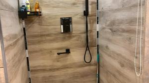 a shower with a hose attached to a wooden wall at Ferienwohnung Meise in Sundern +11 photos