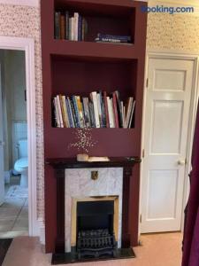 a fireplace in a living room with a book shelf at Hillcrest Bed and Breakfast in Jim Thorpe