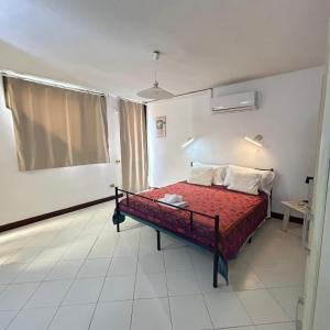 a bedroom with a bed with a red comforter at Room with kitchen & free parking 100 m from the sea in Quartu Sant'Elena