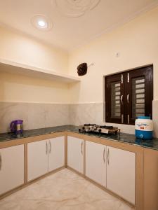 a kitchen with white cabinets and a counter top at Sukoon stays Bhimtal 3 bed in Bhīm Tāl