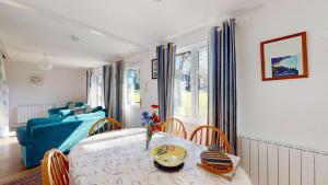 a living room with a table and a blue couch at 87 Strawberry Hill, Tolroy Manor in Hayle