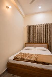 a bedroom with a bed with white sheets and a window at Sukoon stays Bhimtal 3 bed in Bhīm Tāl