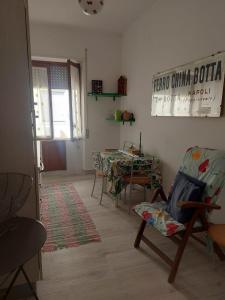 a living room with a table and a chair at Mare Blu' in Crotone