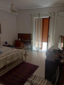 a bedroom with a bed and a desk and a window at Mare Blu' in Crotone