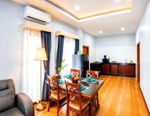 a living room with a table and chairs and a kitchen at Villa Escape Aonang Krabi in Krabi