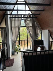 a living room with curtains and a large window at Annfield Cabana in Hatton