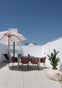 a patio with a table and chairs and an umbrella at Líbere Seville Triana in Seville