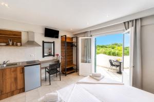 a kitchen and living room with a view of a patio at Nikos Villas - Poolside Getaways in Kavos, Corfu in Kavos +28 photos