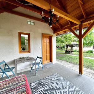 a patio with a wooden roof and a table and chairs at Kisház in Kisoroszi