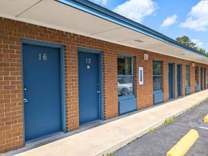 a row of blue doors on a brick building at Gateway Inn in Lake City