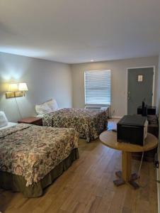 a hotel room with two beds and a table at Gateway Inn in Lake City