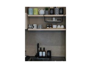 a kitchen counter with a sink and shelves at Qerret Boutique Studio Apartment in Golem