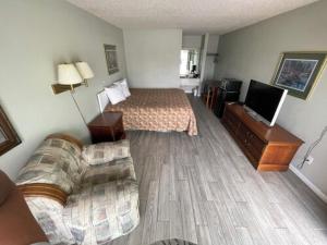 a hotel room with a bed and a couch at Gateway Inn in Lake City +5 photos