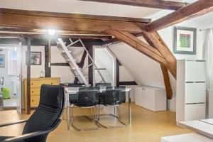 a dining room with a table and black chairs at Alte Schmiede Ellrichshausen 1 in Satteldorf +7 photos
