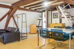 a room with a table and chairs and a ladder at Alte Schmiede Ellrichshausen 1 in Satteldorf