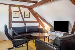 a living room with a couch and a tv at Alte Schmiede Ellrichshausen 1 in Satteldorf