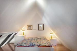 a bedroom with a bed and two lamps in a attic at Alte Schmiede Ellrichshausen 1 in Satteldorf