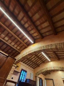 a room with wooden ceilings and windows in a building at Villa Iulia - VIBRA in Controguerra