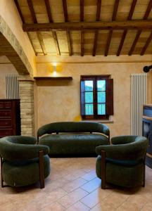 a living room with green couches and chairs at Villa Iulia - VIBRA in Controguerra
