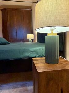 a bedroom with a bed and a lamp on a table at Villa Iulia - VIBRA in Controguerra