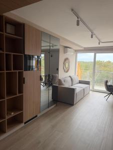 a living room with a couch and a large window at Apartament Sosnowy 45 in Rowy
