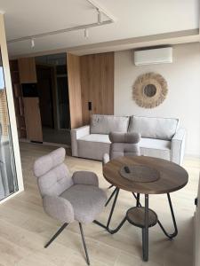 a living room with a table and chairs and a couch at Apartament Sosnowy 45 in Rowy