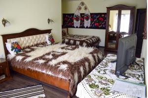 a bedroom with a large bed and a tv at Pensiunea Baias in Bîrsana +3 photos