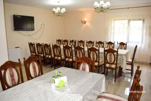 a dining room with a table and a group of chairs at Pensiunea Baias in Bîrsana