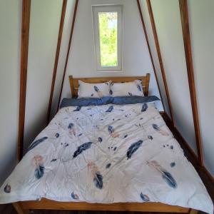 ein Schlafzimmer mit einem Bett mit blauen Federn in der Unterkunft Silent A-FRAME in Brăteşti