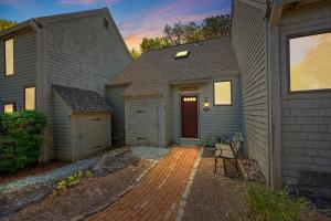 a home with a garage and a house at Sea Spark - Cape Escape with Pool Access in Mashpee