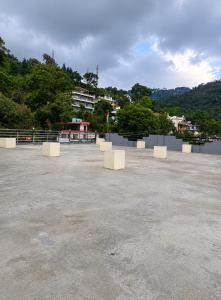 a large parking lot with white benches in it at Sukoon stays Bhimtal 3 bed in Bhīm Tāl +5 photos