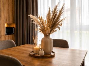 a table with a vase and a candle on it at Апартаменти VIP in Ternopil +5 photos
