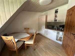 a room with a table and chairs and a kitchen at Wohnung an der schönen Aue Stadtzentrumsnähe in Fulda +10 photos