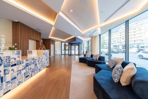 a lobby of a building with couches and windows at Jupiter Porto Hotel - Rooftop & Spa in Porto