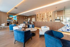 a lobby with blue chairs and a bar at Jupiter Porto Hotel - Rooftop & Spa in Porto