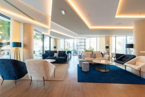 a lobby with couches and tables and windows at Jupiter Porto Hotel - Rooftop & Spa in Porto +25 photos