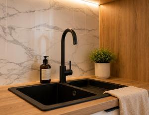 a kitchen sink with a bottle of wine on it at Апартаменти VIP in Ternopil