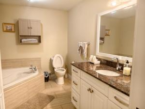 a bathroom with a sink and a tub and a toilet at Near Cavendish Beach-1 in Stanley Bridge +37 photos
