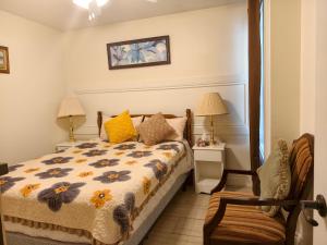a bedroom with a bed and two lamps and a chair at Near Cavendish Beach-1 in Stanley Bridge