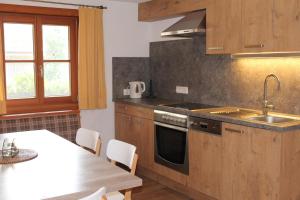 a kitchen with a sink and a stove and a table at Uhlerhof in Stumm