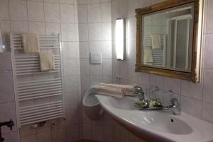 a white bathroom with a sink and a mirror at Uhlerhof in Stumm +47 photos
