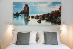 a bedroom with a bed with rocks in the ocean at Aulino House in Catania